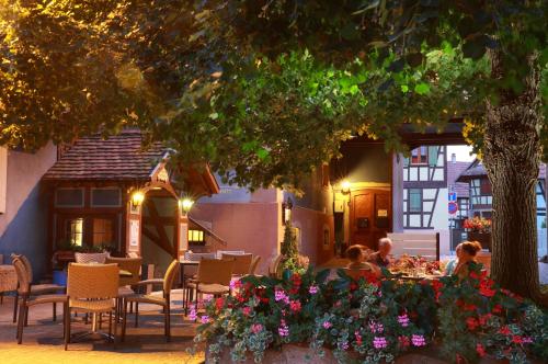 a group of people sitting at a table in a restaurant at Hotel Restaurant Père Benoît in Entzheim