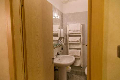 a bathroom with a sink and a toilet and towels at Albergo della Posta in Taverna