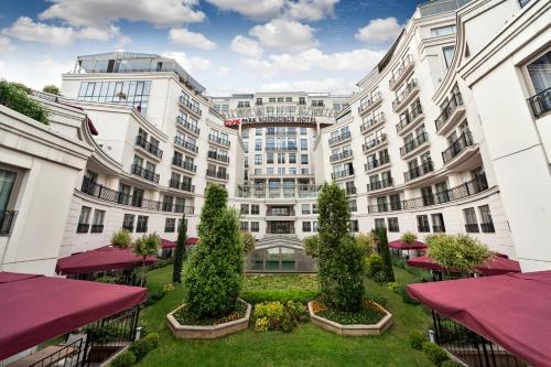 a large white building with trees in a courtyard at CVK Park Bosphorus Hotel Istanbul in Istanbul