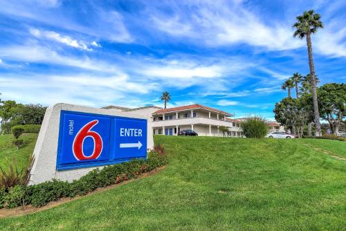 um sinal em frente a uma casa com palmeiras em Motel 6-Carlsbad, CA Beach em Carlsbad