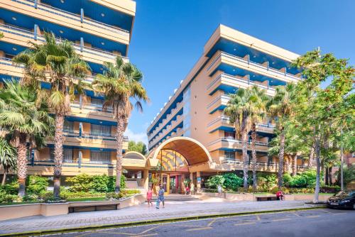 un edificio con palmeras frente a una calle en 4R Playa Park, en Salou