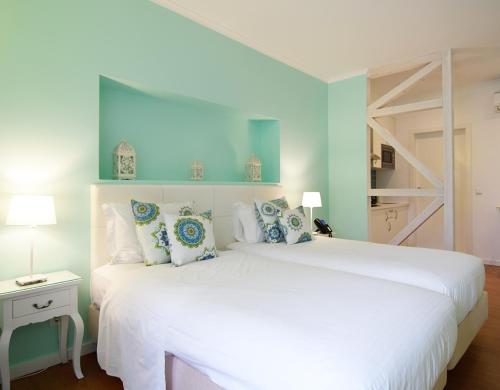 a bedroom with a large white bed with blue walls at Rossio Apartments in Lisbon