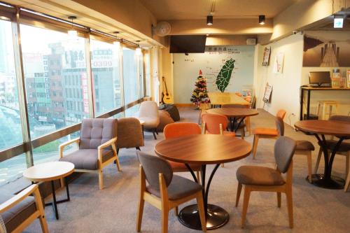 een restaurant met tafels en stoelen en een kerstboom bij Trip GG Hostel in Kaohsiung