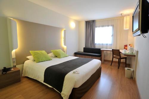 a hotel room with a large bed and a desk at Travelodge Málaga Airport in Málaga