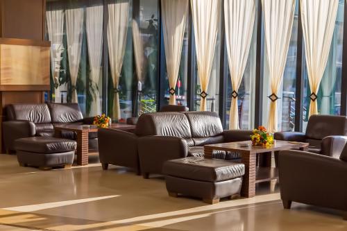 a lobby with couches and tables and large windows at Grand Hotel Napoca in Cluj-Napoca