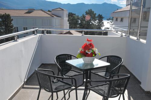 einen Tisch und Stühle auf einem Balkon mit einer Blumenvase in der Unterkunft Hotel Oaza in Budva