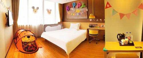 een slaapkamer met een kinderkamer met een bed en een bureau bij IU Hotel Guangzhou Taihe Square in Guangzhou