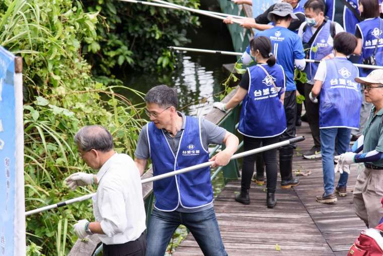 台塑生醫去年9月集結員工、志工、居民在宜蘭龍潭湖畔悠活園區清除274公斤的小花蔓澤蘭。(圖：台塑生醫提供)