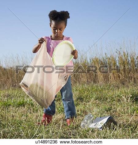 Stock Images of Young girl picking up litter u14891236.