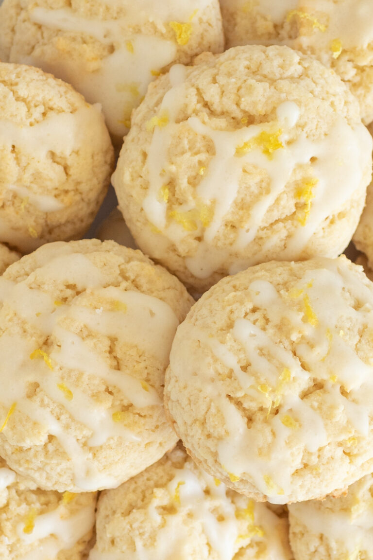 plate fulled of lemon cookies with light white icing and a little lemon zest