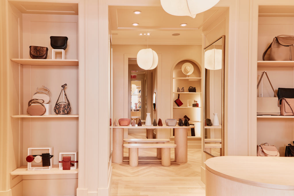 Interior of a store with shelves displaying various items and mirrors on the wall.