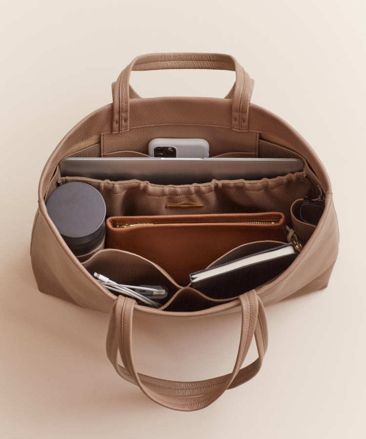 Open handbag containing various items like a phone and sunglasses.