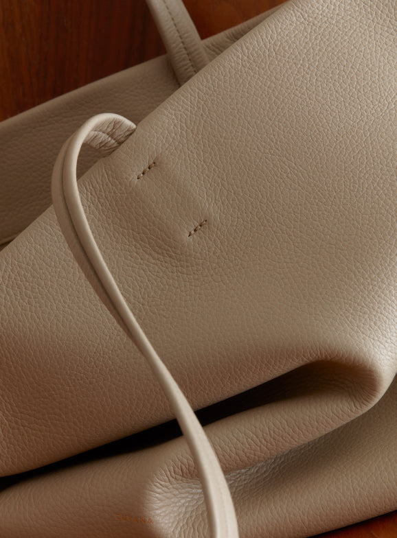 Close-up of a textured handbag with a visible handle.