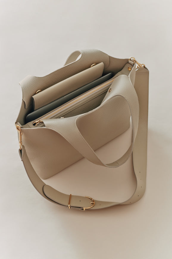 Open handbag with contents visible on a plain background.