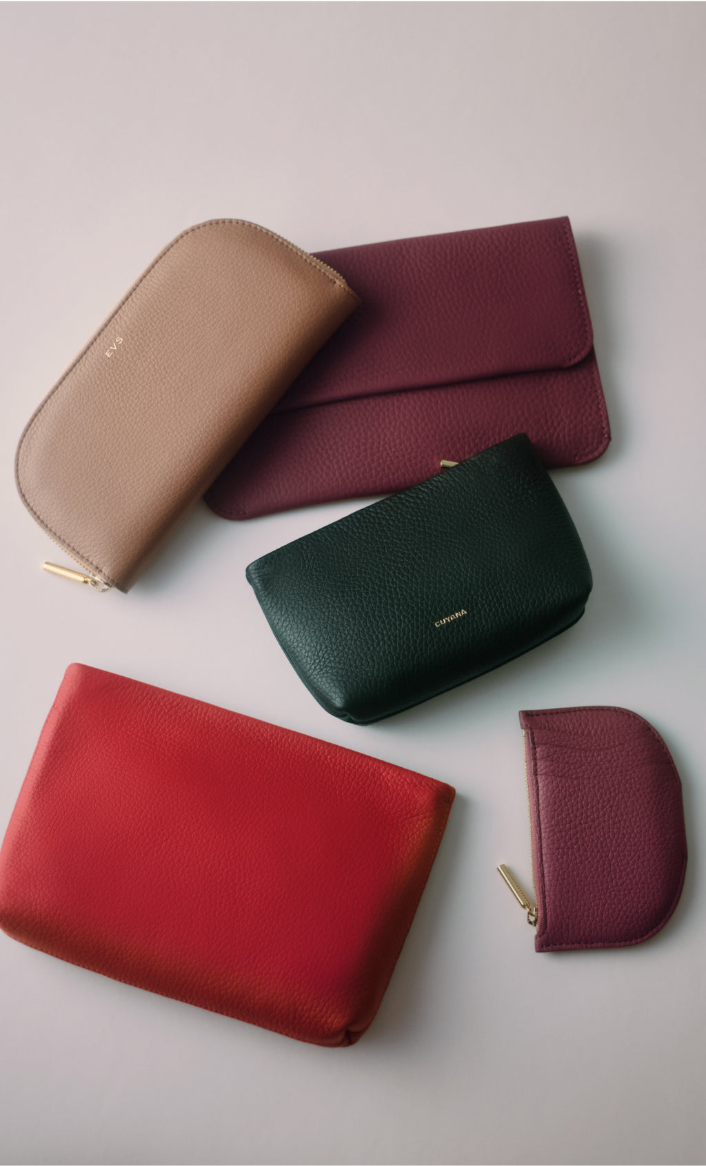 Various leather pouches and wallets arranged on a flat surface.