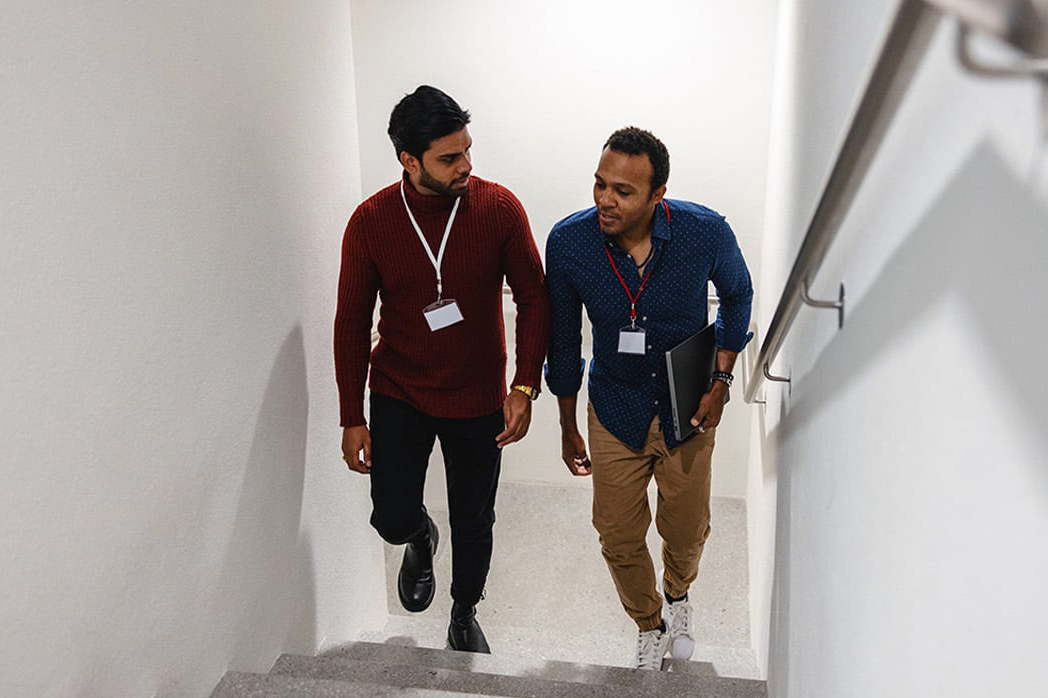 Two men talking and walking up some stairs.