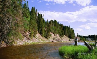 Rocky river with fisherman on the shoreline.