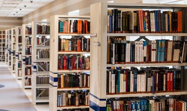 Biblioteca com livros organizados em prateleiras.