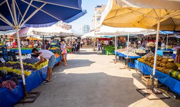 Corredor de uma feira com barracas de comida e outros produtos.