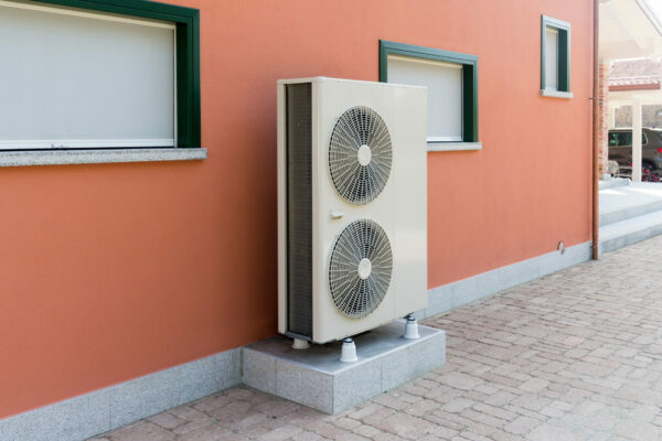 residential heat pump on the side of a house