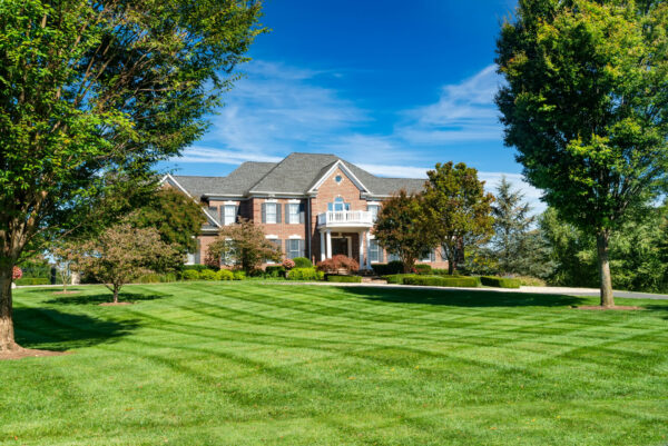 large brick home with big front yard and landscaping