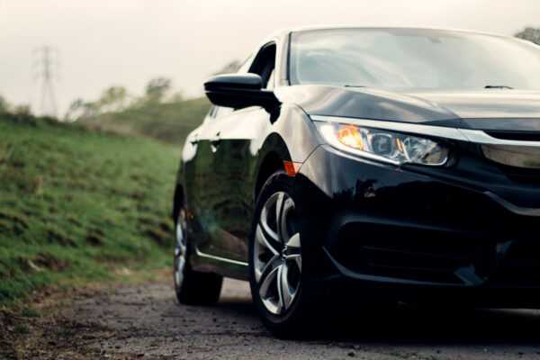 closeup front headlight and passenger side of black car