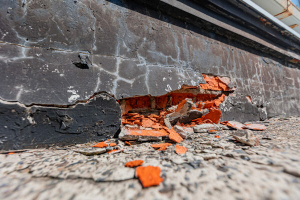 Crack in brick building wall of home with cracked defects foundation