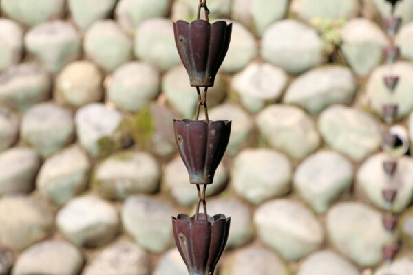 Japanese drainage chain from rain gutter and stone wall background, to prevent slipping from flood water and protect for droplet to head.