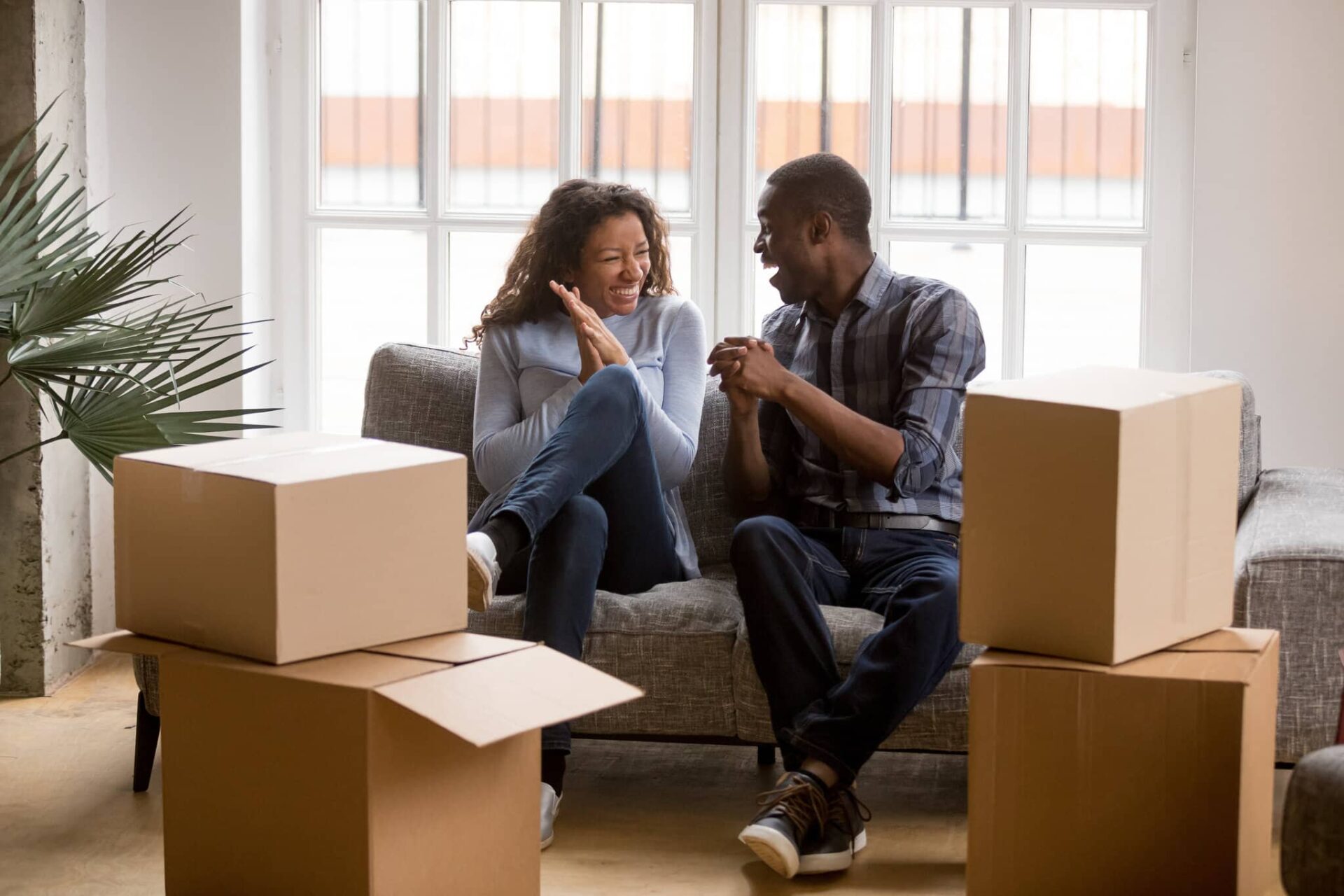 Happy couple insured by Lemonade renters insurance for their new rental unit in a modest apartment building