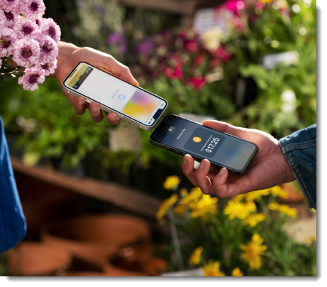 Two people holding phones to tap to pay