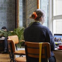 A person browses Art Fund's website sat in a cafe