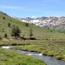 A river running through a valley. Mountains behind indicate the watershed.