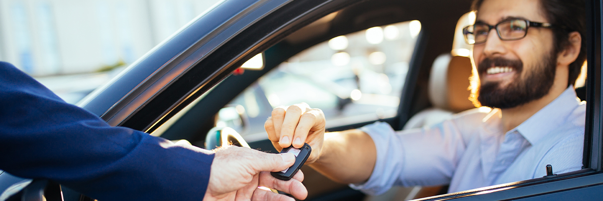 Young woman driving away in first new car