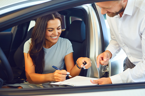 A young woman buys a new car.