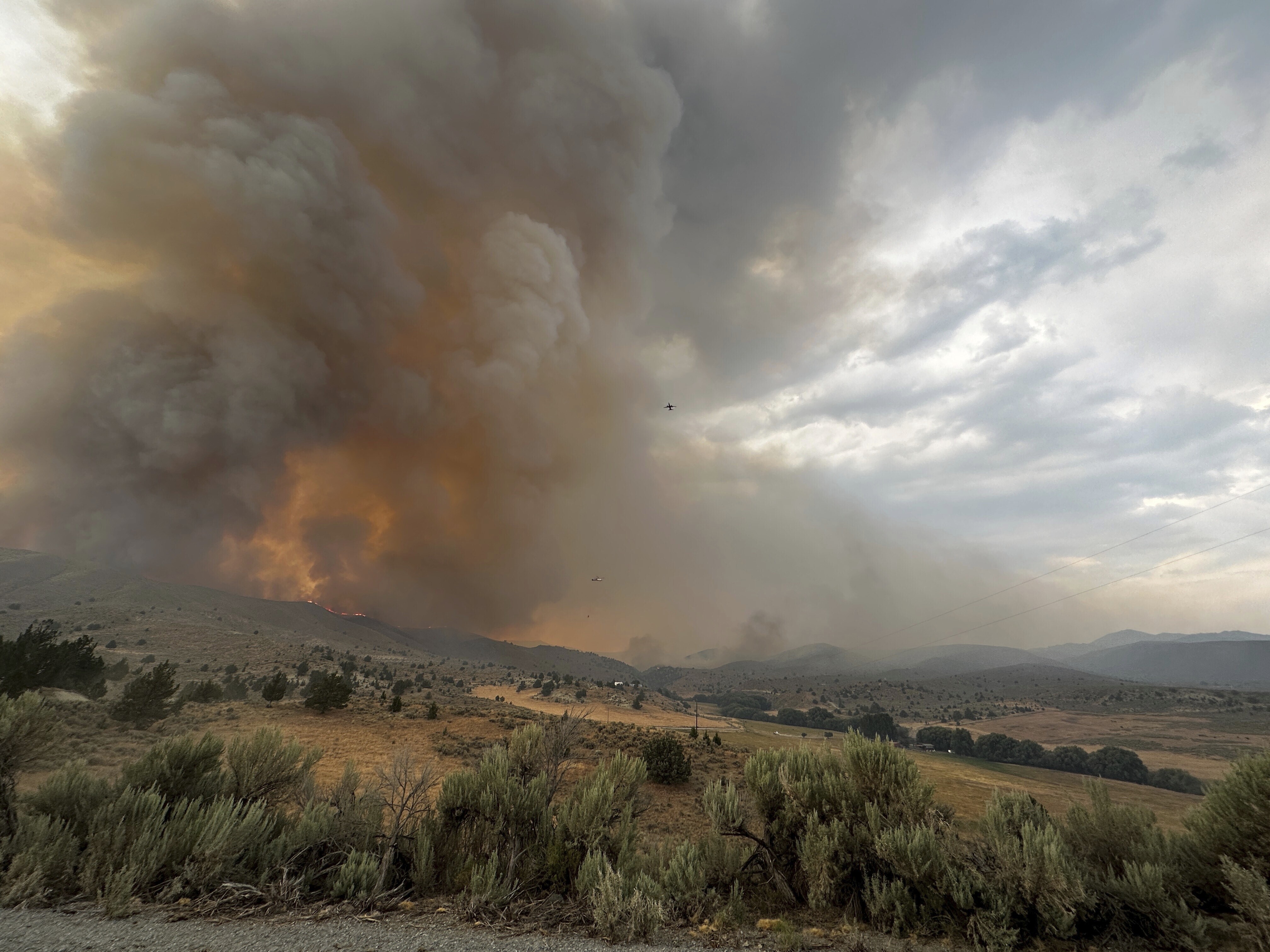 In this image provided by the U.S. Department of Agriculture Forest Service, smoke rises from a wildfire on Monday, July 22, 2024, near Durkee, Ore. In eastern Oregon, evacuation orders were lifted Thursday for the city of Huntington, population 500, after a severe thunderstorm late Wednesday brought some rain and cooler temperatures to the nearly 630 square miles (1,630 square kilometers) burned by the Durkee Fire, the nation's biggest, and another nearby blaze. (Brett Brown/USDA Forest Service via AP)