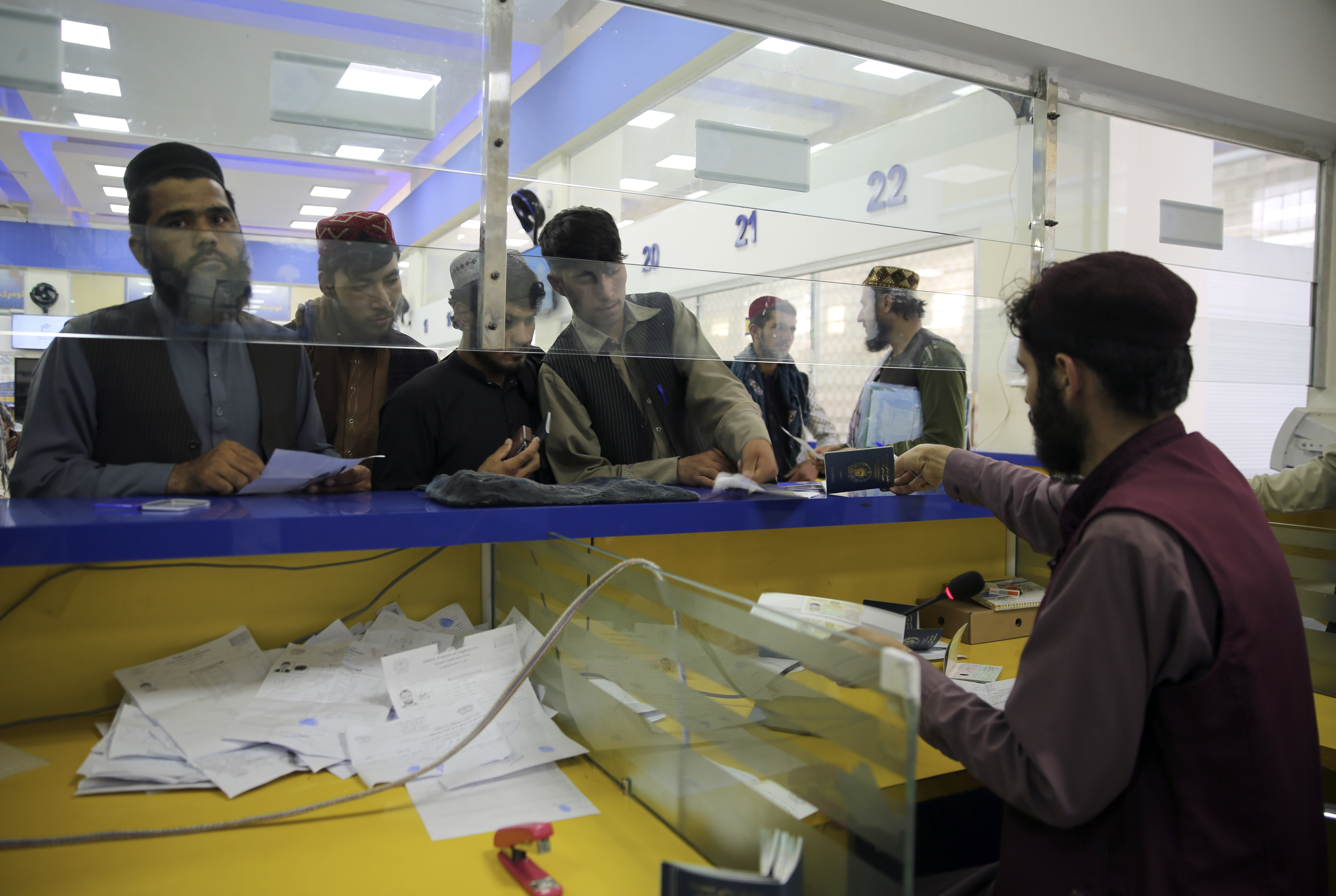 Afghan men wait to receive their passports from the main post office in the city of Kabul, Afghanistan, Wednesday, July 3, 2024. In parts of Afghanistan where there are no street names or house numbers, utility companies and their customers have adopted a creative approach for connecting. They use mosques as drop points for bills and cash, a "pay and pray" system. (AP Photo/Siddiqullah Alizai)