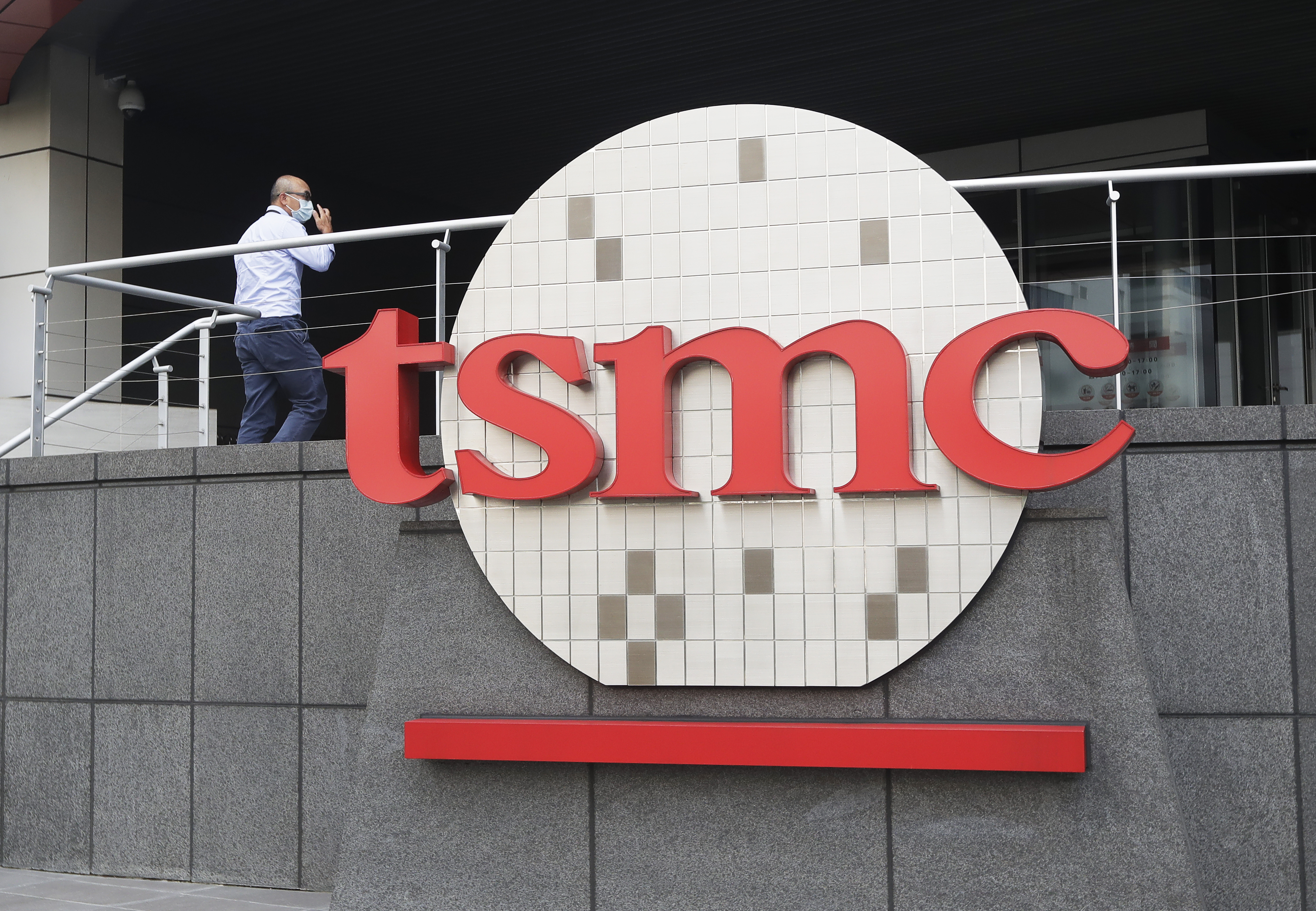 FILE - A person walks into the Taiwan Semiconductor Manufacturing Co., headquarters in Hsinchu, Taiwan on Oct. 20, 2021. The Biden administration pledged Monday, April 8, 2024, to provide up to $6.6 billion so that a Taiwanese microchip giant can expand the facilities it is already building in Arizona and ensure that the world most-advanced chips are produced domestically for the first time. (AP Photo/Chiang Ying-ying, File)