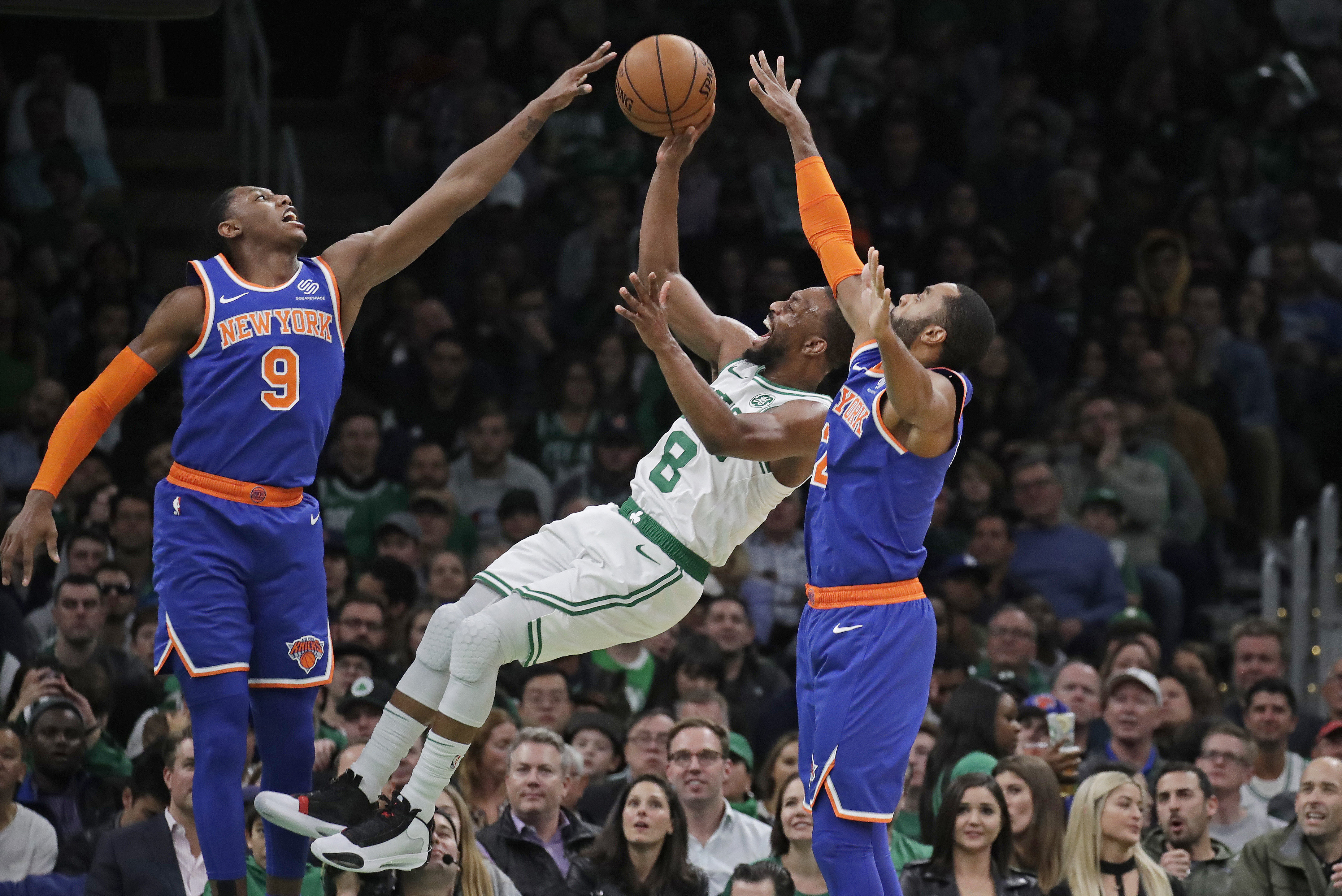 FILE - Boston Celtics guard Kemba Walker (8) shoots between New York Knicks guard RJ Barrett (9) and guard Wayne Ellington during the second half of an NBA basketball game Friday, Nov. 1, 2019, in Boston. Kemba Walker, a four-time All-Star guard, says he’s retiring from basketball. Walker, 34, wasn’t in the NBA this past season but did play in the EuroLeague with AS Monaco. He announced his decision Tuesday, July 2, 2024, on social media. (AP Photo/Elise Amendola, File)
