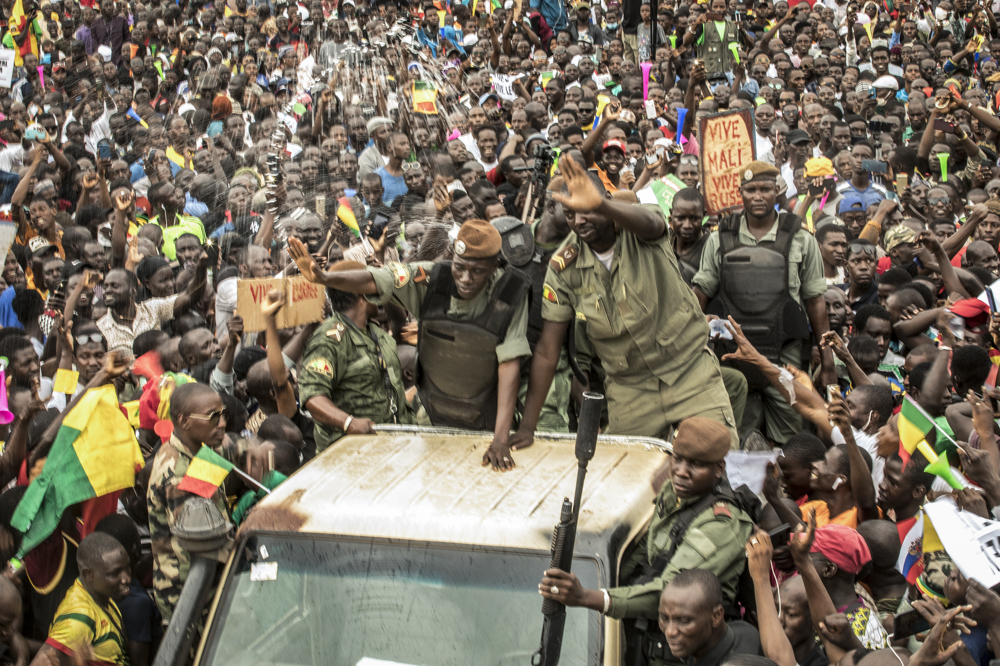 FILE - An unidentified representative of the junta waves from a military vehicle as Malians supporting the recent overthrow of President Ibrahim Boubacar Keita gathers to celebrate in the capital Bamako, Mali, on Aug. 21, 2020. The coup-hit nations of Niger, Mali and Burkina Faso were meeting on Saturday, July 6, 2024 in their first regional summit that officially sets them apart from the West Africa regional bloc after earlier announcing they were leaving the bloc. (AP Photo/File)