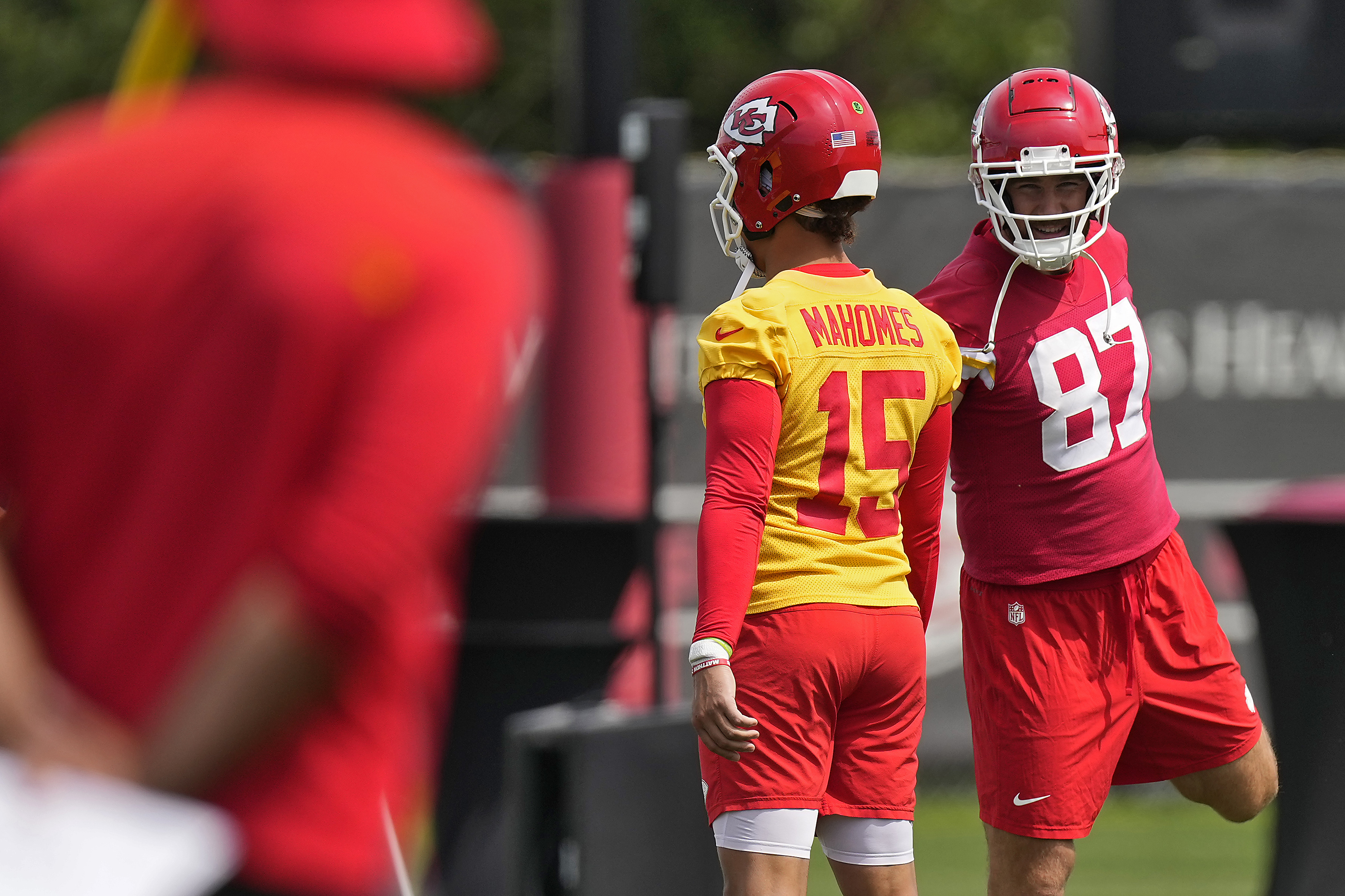 Kansas City Chiefs quarterback Patrick Mahomes (15) and tight end Travis Kelce (87) talk during NFL football practice Tuesday, June 11, 2024, in Kansas City, Mo. (AP Photo/Charlie Riedel)