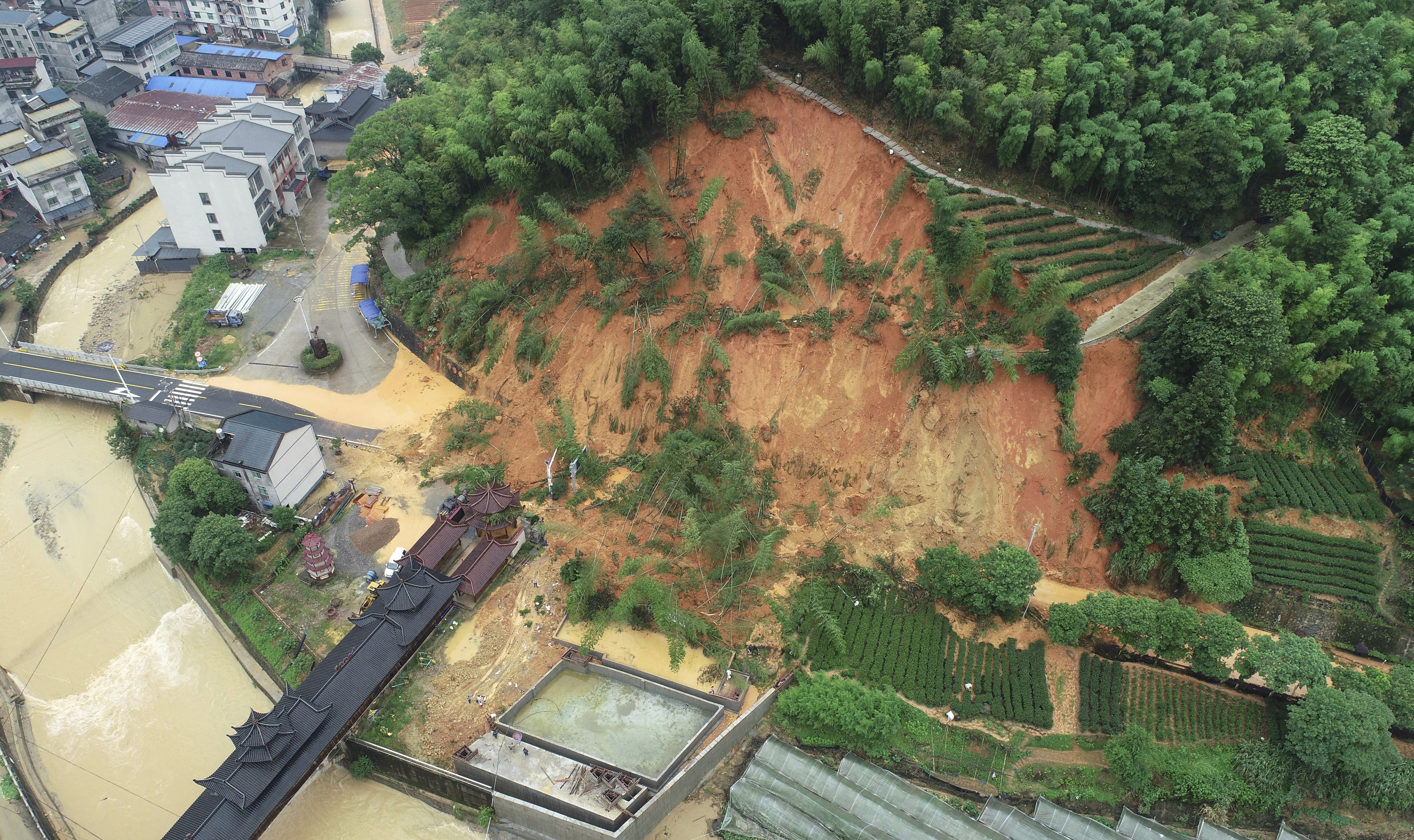 In this photo released by Xinhua News Agency, an aerial drone photo taken on June 16, 2024 shows a landslide in an area affected by torrential rains in Tieshan Township of Zhenghe County, Nanping City in southeastern China's Fujian Province. Southern China was reeling Tuesday from heavy rains that triggered landslides killing at least nine people, knocking out power for entire villages and burying crops. Meanwhile, northern parts of the country are battling drought, as the country faces two extremes of severe weather.(Huang Jiemin/Xinhua via AP)