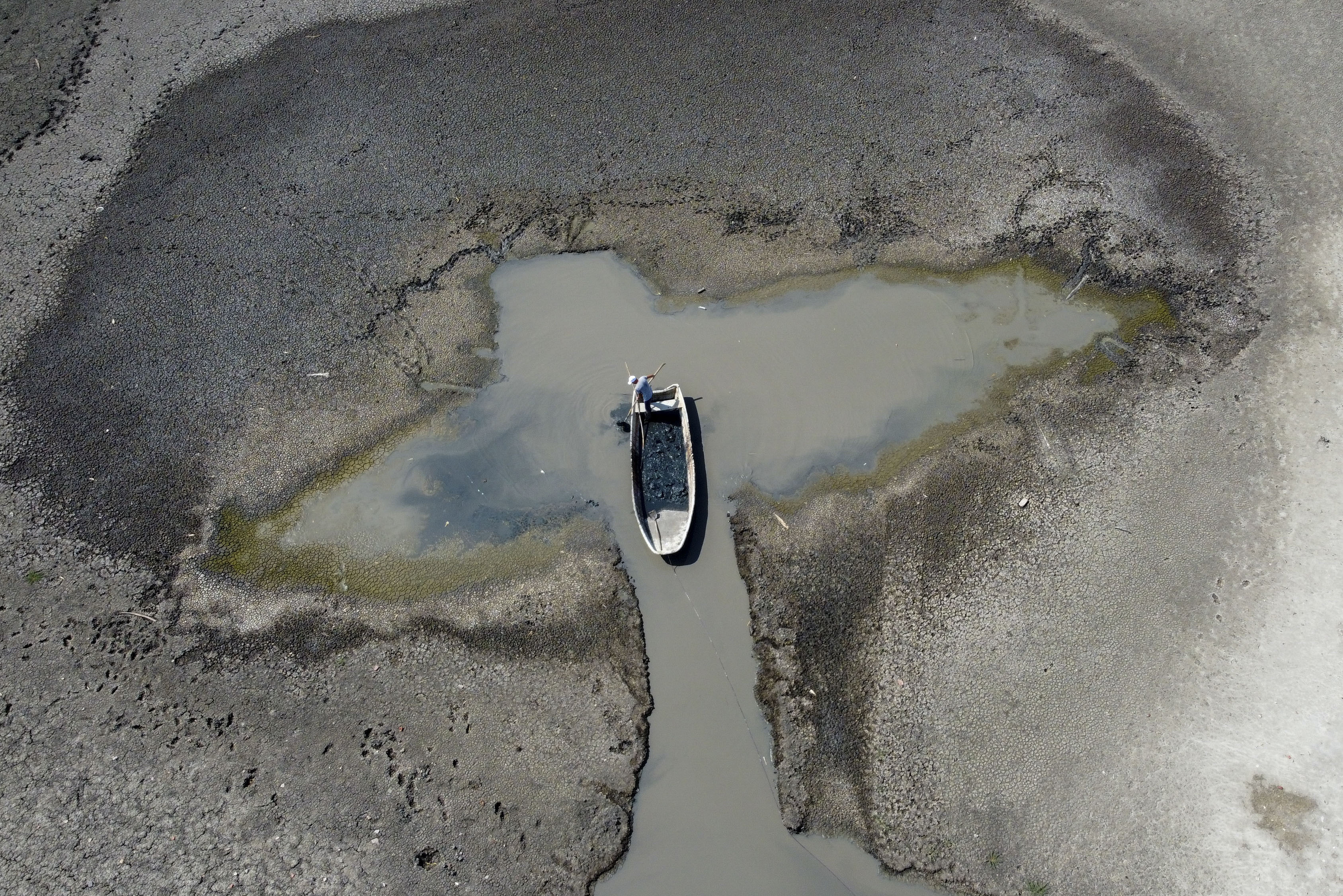 A man collects mud that is used in medical therapy from the Rusanda salty lake that has dried out completely, near Melenci, Serbia, Wednesday, Sept. 4, 2024. Experts say the summer of 2024 in the Balkans was the hottest since measurements started more than 130 years ago. (AP Photo/Darko Vojinovic)