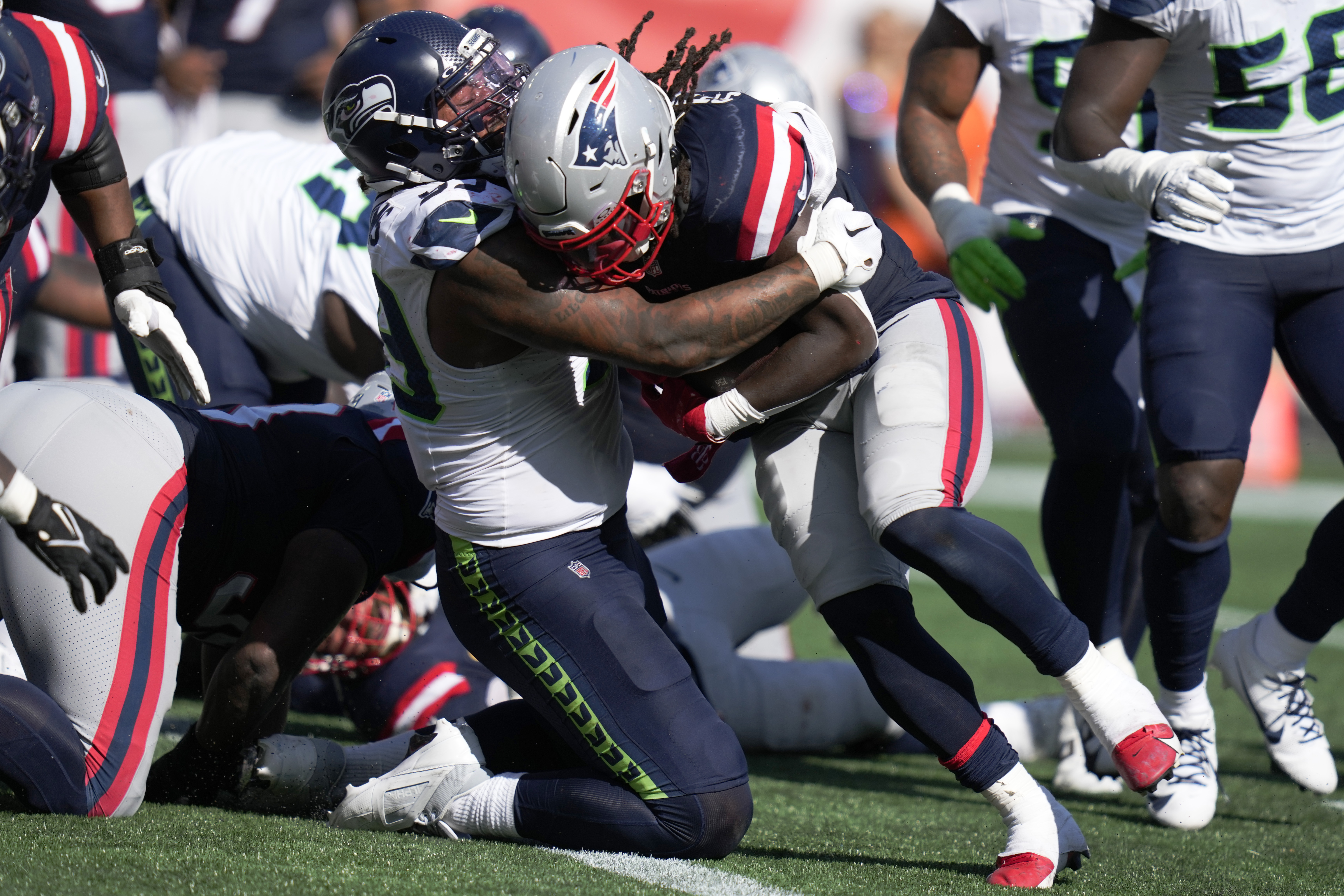 New England Patriots running back Rhamondre Stevenson, center right, runs into the end zone for a touchdown as Seattle Seahawks defensive end Leonard Williams, center left, defends in the second half of an NFL football game, Sunday, Sept. 15, 2024, in Foxborough, Mass. (AP Photo/Charles Krupa)