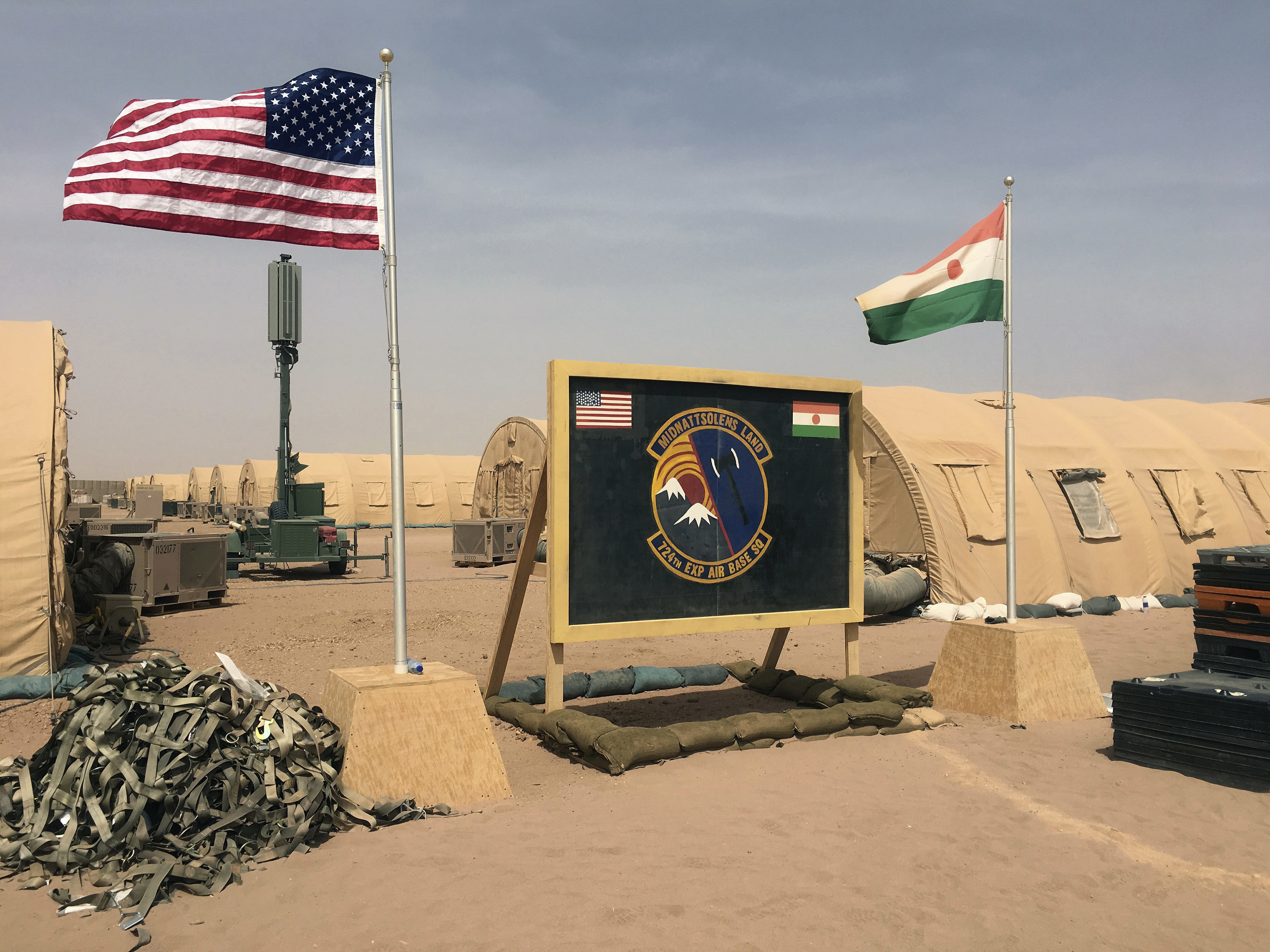 FILE- In this file photo taken Monday, April 16, 2018, a U.S. and Niger flag are raised side by side at the base camp for air forces and other personnel supporting the construction of Niger Air Base 201 in Agadez, Niger. The US handed over its last military base in Niger to the country's authorities, the US Department of Defense and Niger’s Ministry of Defense announced in a joint statement on Monday, Aug. 5, 2024. (AP Photo/Carley Petesch, File)