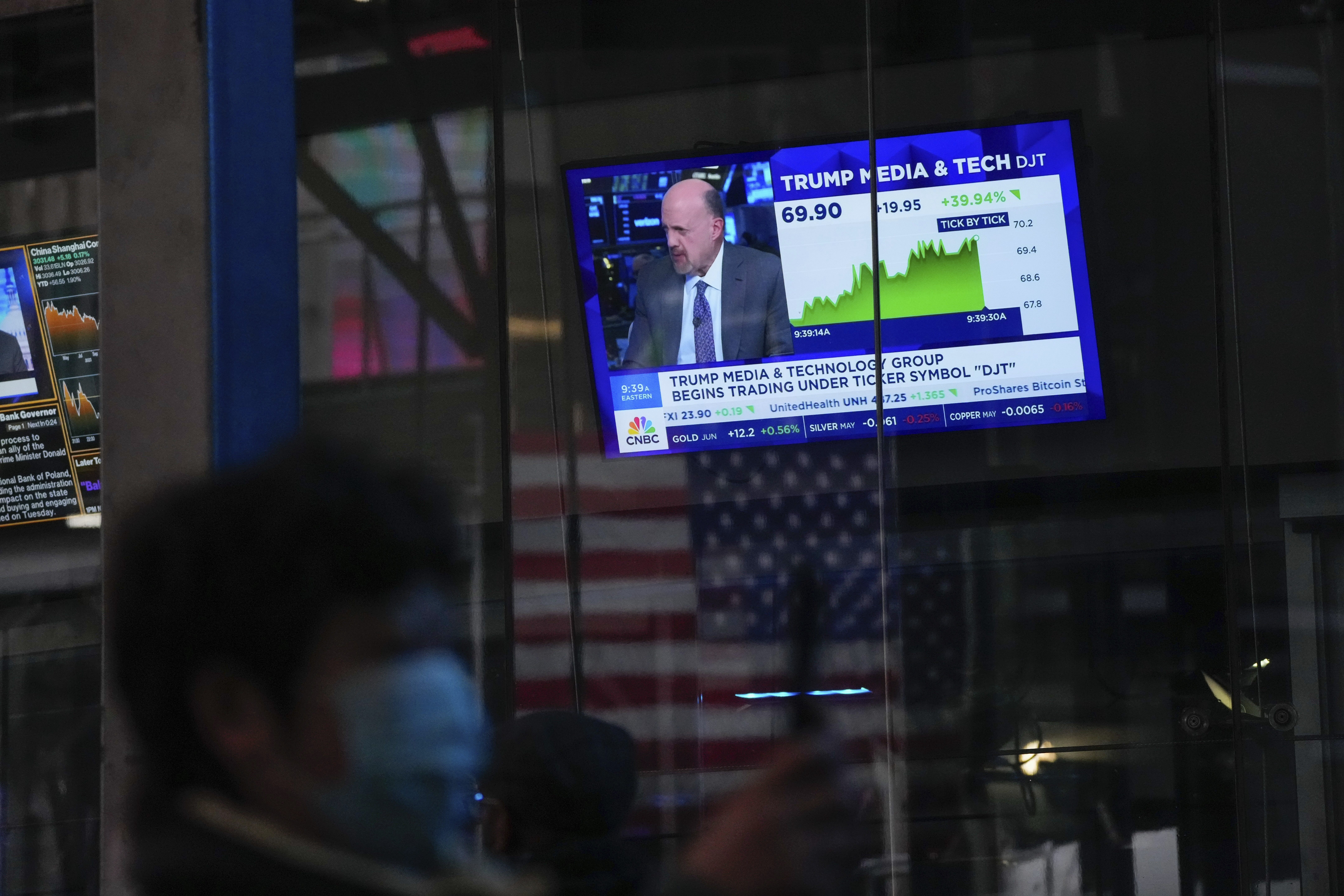 FILE - Pedestrians walk past a Nasdaq window displaying news on Trump Media on March 26, 2024, in New York. (AP Photo/Frank Franklin II, File)