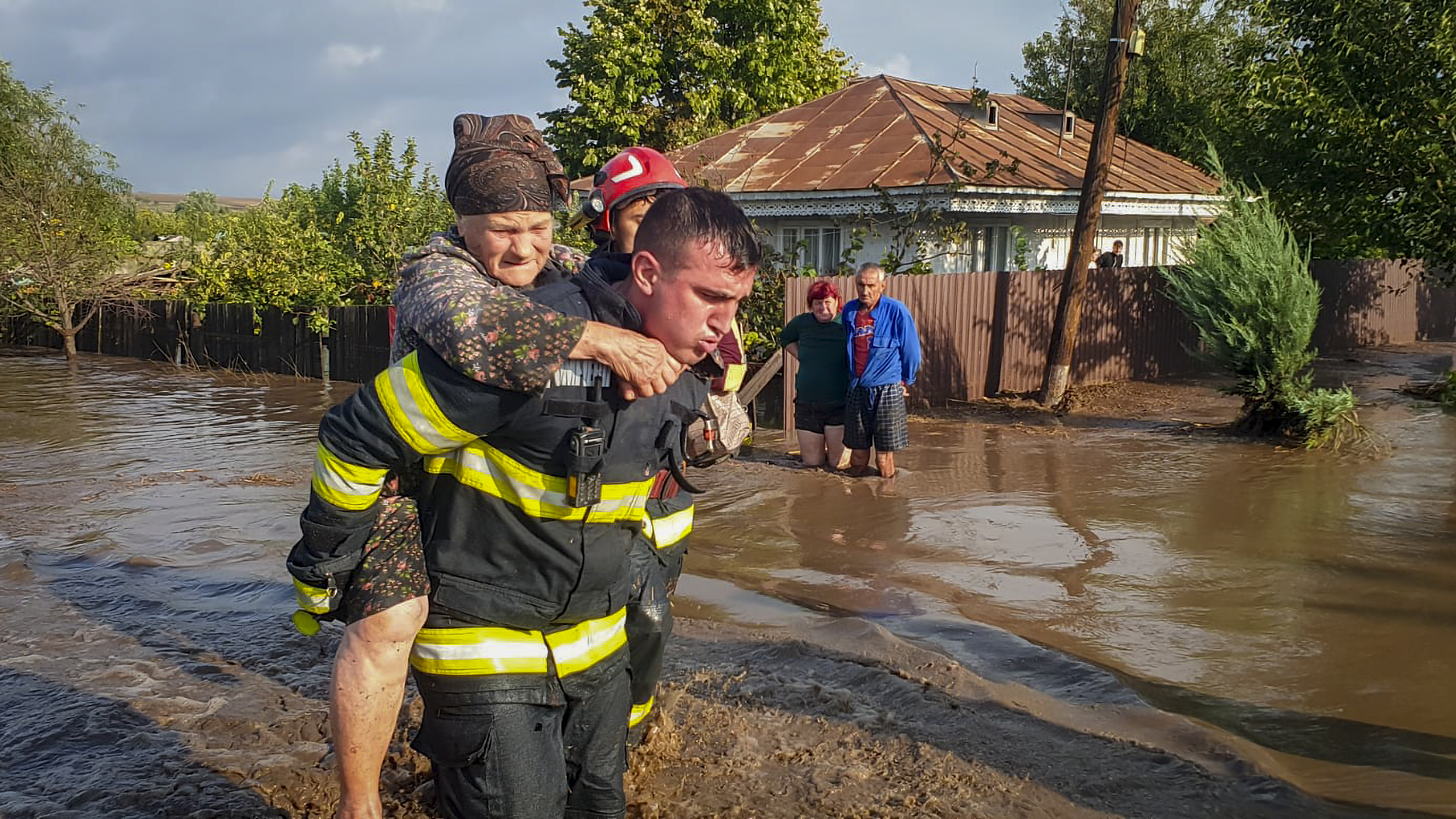 In this photo released by the Romanian Emergency Services Galati (ISU Galati), a rescuer carries a woman in Pechea, Romania, Saturday, Sept. 14, 2024 after torrential rainstorms left scores of people stranded in flooded areas. (Romanian Emergency Services - ISU Galati via AP)