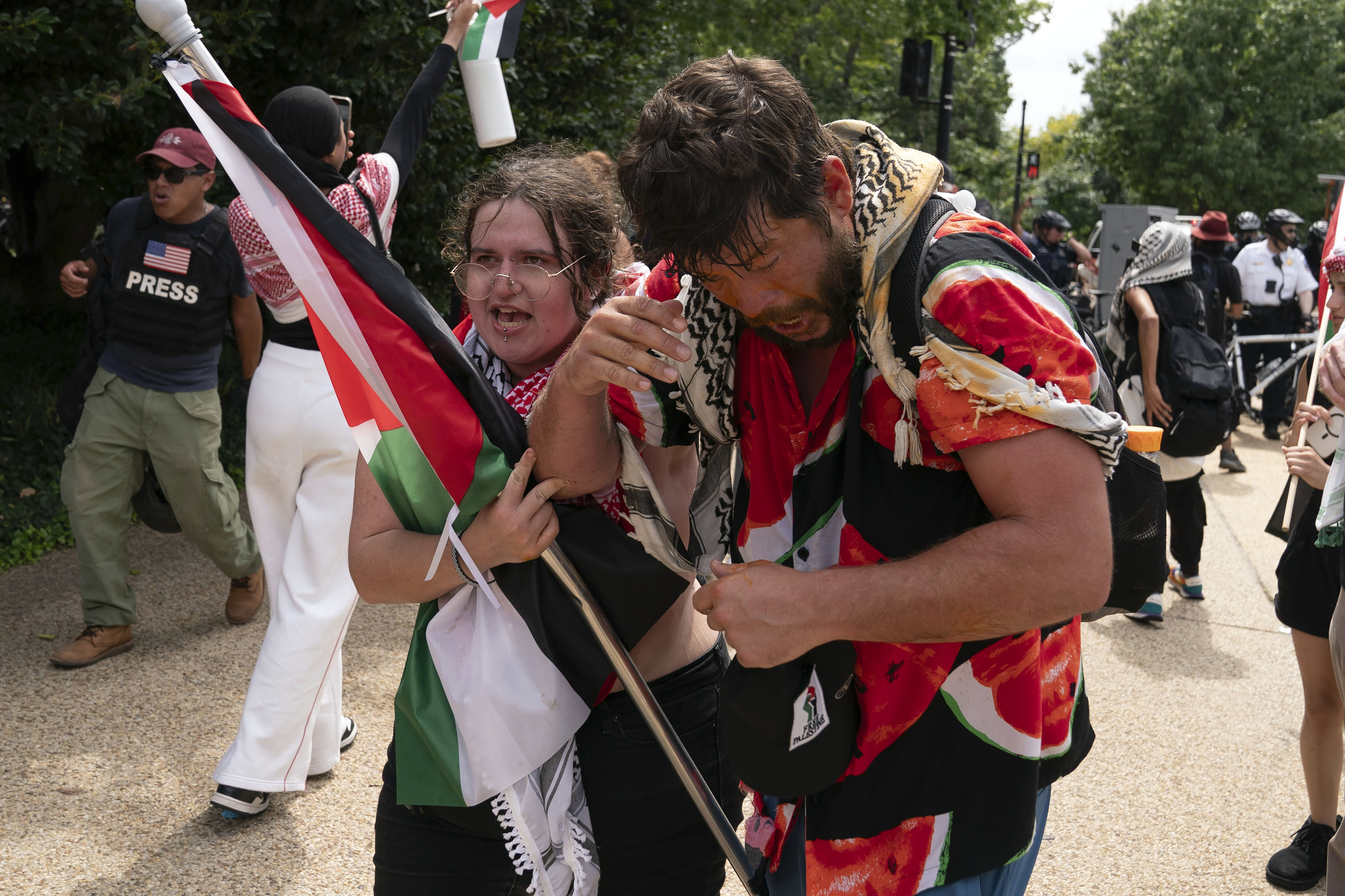 Demonstrators react after being exposed to a chemical irritant as they protest the visit of Israeli Prime Minister Benjamin Netanyahu on Capitol Hill, Wednesday, July 24, 2024, in Washington. (AP Photo/Jose Luis Magana)