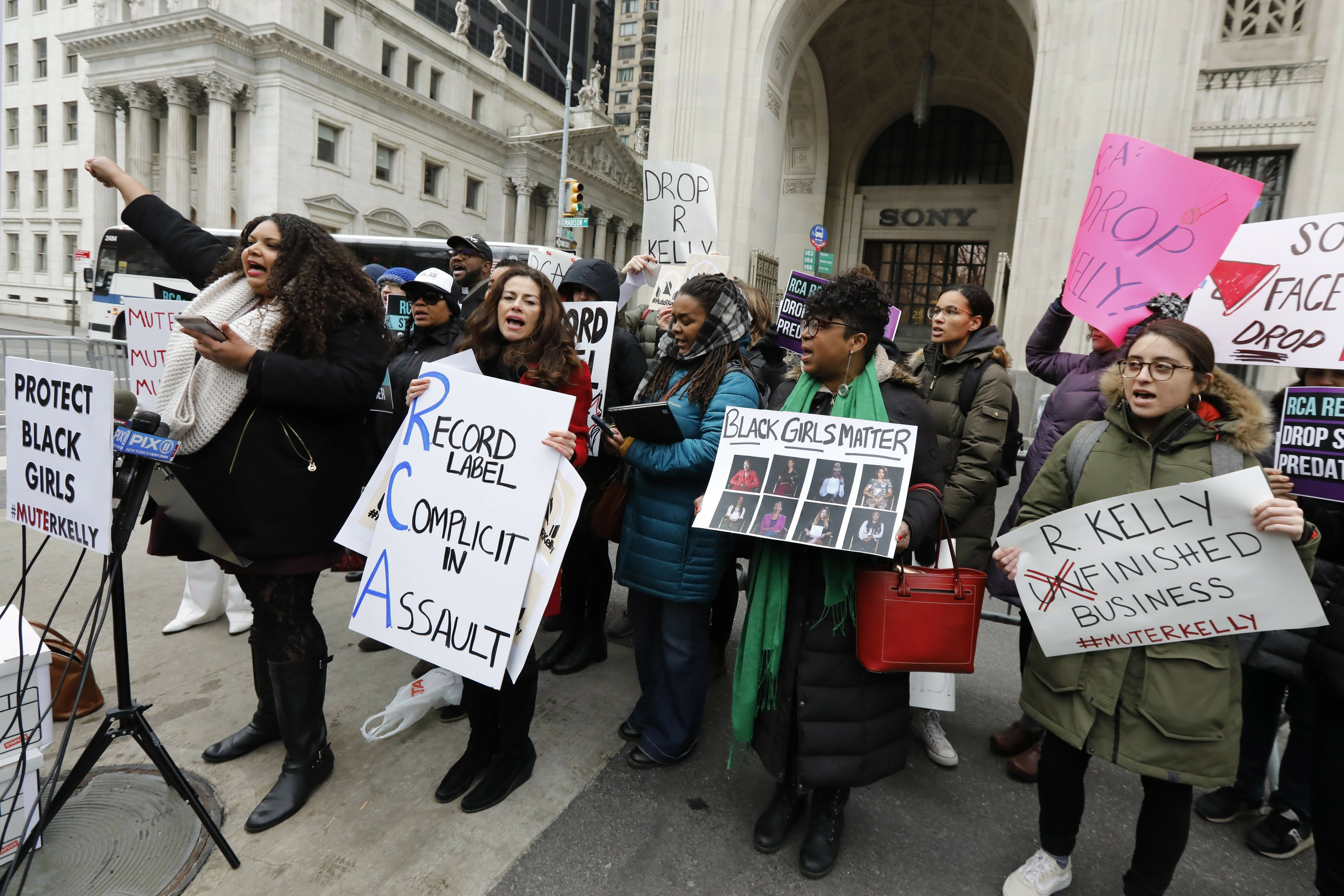 
              FILE - In this Jan. 16, 2019 file photo, Sonja Spoo, left, associate campaign director of Ultra Violet, leads chants during an R. Kelly protest outside Sony headquarters in New York. Multiple outlets have reported that Sony Music has dropped embattled R&B star R. Kelly from its roster. The announcement comes two weeks after the popular documentary series "Surviving R. Kelly" recently drew fresh attention to the sex abuse allegations against R. Kelly, which has dogged him most of his career. (AP Photo/Richard Drew, File)
            