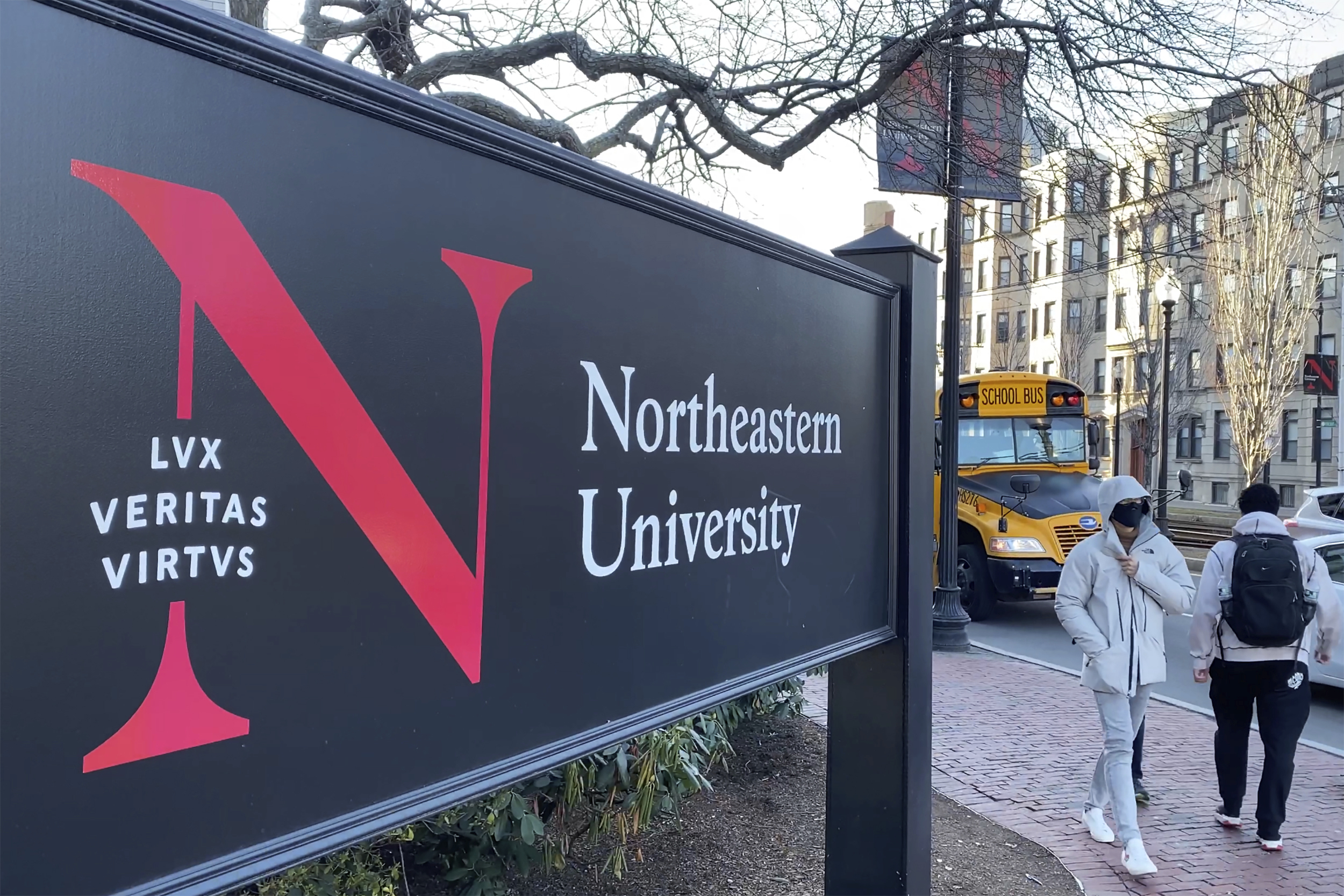 FILE - In this Jan. 31, 2019 file photo, pedestrians walk near a Northeastern University sign on the school's campus in Boston. A former lab manager at Northeastern University has been convicted, Friday, June 28, 2024, of staging a hoax explosion at the Boston campus and then lying about what happened to a federal agent. (AP Photo/Rodrique Ngowi, File)