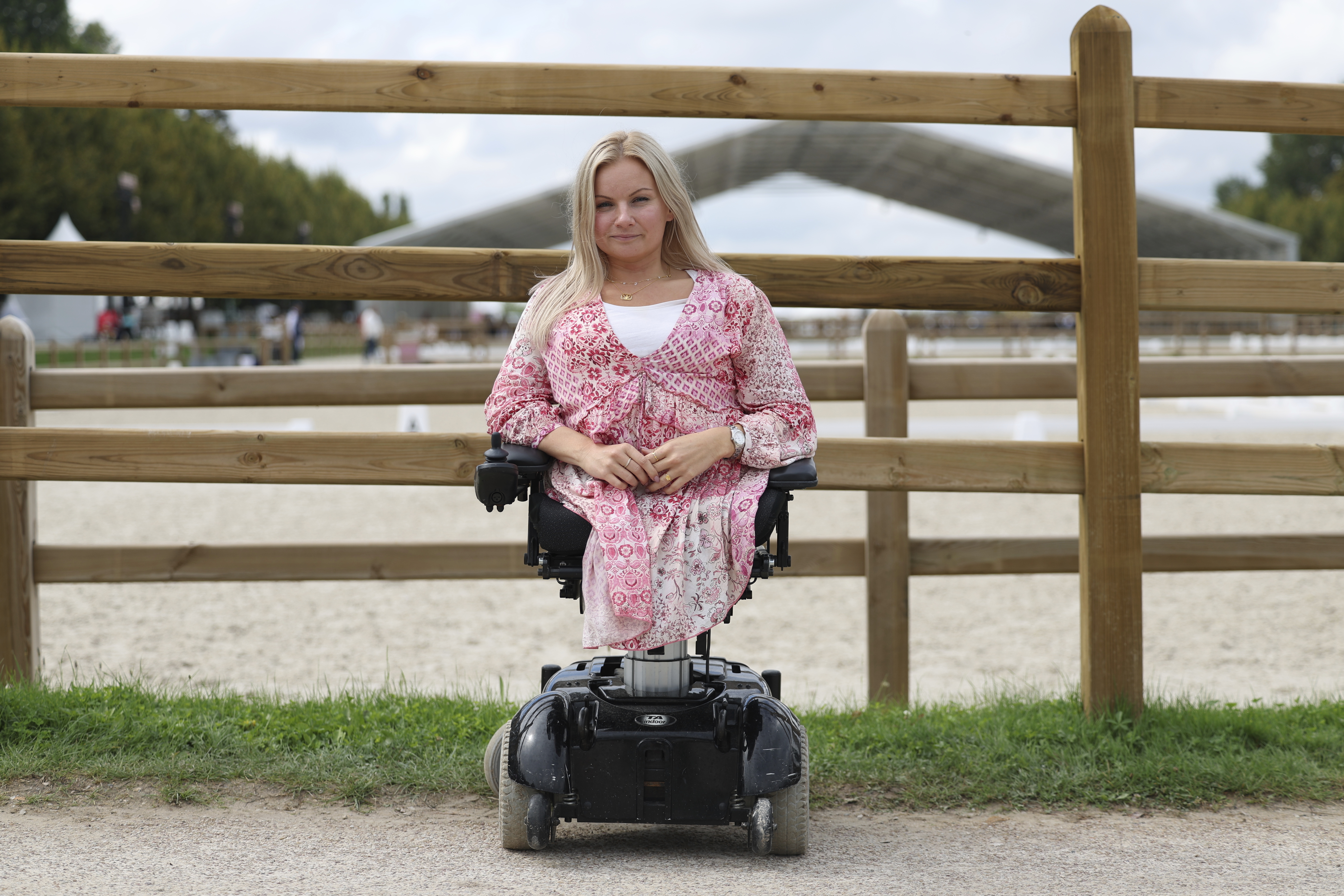 Stinna Tange Kaastrup of Denmark, a consultant for disability access for both the Olympic and Paralympic Games for the Versailles venue for Paris 2024, poses in front of the practice arena at Château de Versailles, Saturday, Sept. 7, 2024. (AP Photo/Kileigh Kane)